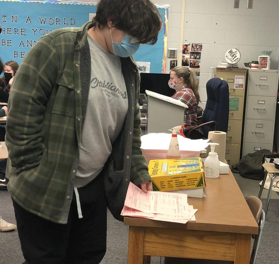 Junior Garrett Franke hands in his class sign up sheet in English teacher Erika Pethan’s first hour.