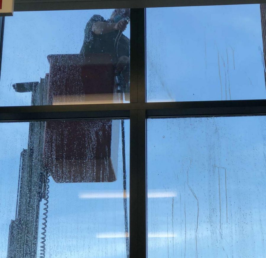 Custodian Jeremie Schmidt washes eggs off of the windows. Berlin High School was egged on the night of Thursday, Sept. 23.