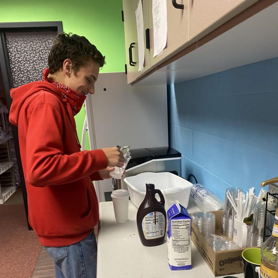 Junior Tyler Kutcher works in School Grounds preparing drinks. The coffee shop opened for business Sept. 13. They are open for delivery first, second and third hour. 