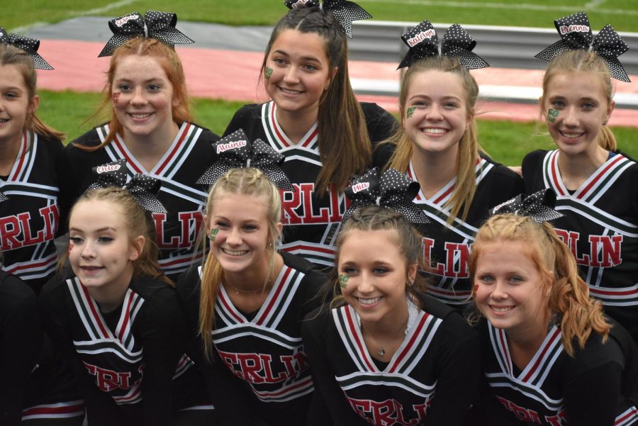 Cheer team gathers around the student section for multiple photos before the start of the football game. 
