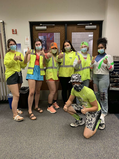 From left to right seniors, Alexis Laude, Cecilia Bruce-DeMuri, Kaylee Olson, Violet Lueck, Ella Resop, Amirrah Hudson, Raymond Hartmann Dress up for “Neon Wednesday” for Homecoming week.