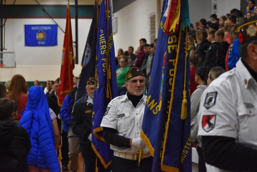 Veteran Paul Cismoski carries a flag during the retiring of the colors at the Veterans Day program. 