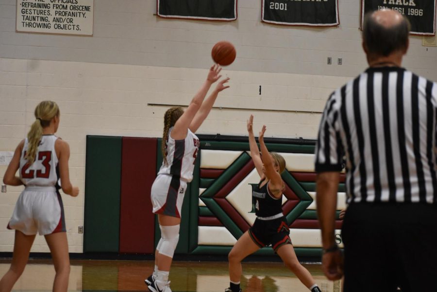 Forward Madison Mertens shoots from the low wing with a PGL defender playing tight defense.