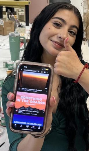 Senior Kimberly Cobos Lara listening to “Something in the Orange” in art class.