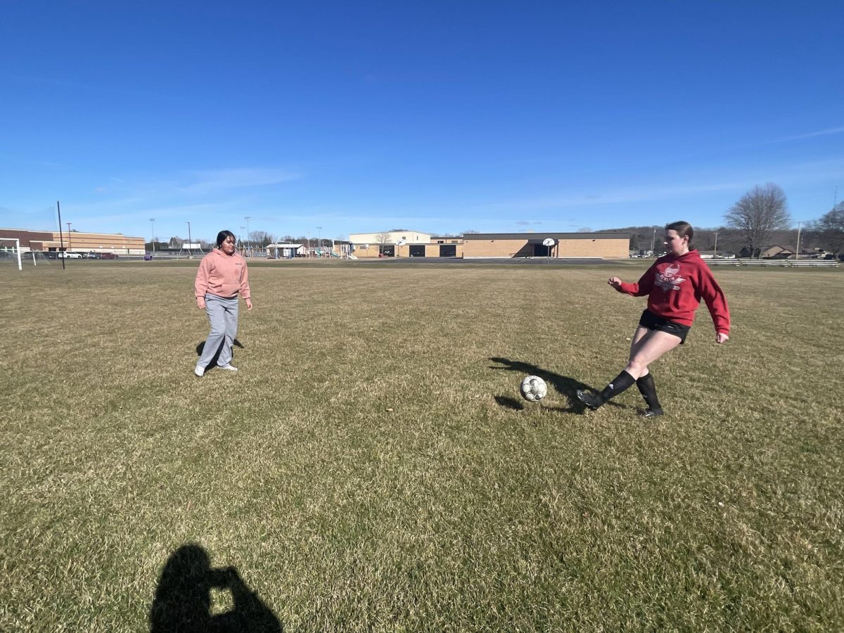 Senior Delilah Rubio and sophomore Kate Sharff pass the ball around to each other, in the freezing cold weather, on March 18 at the first day of practice. 
