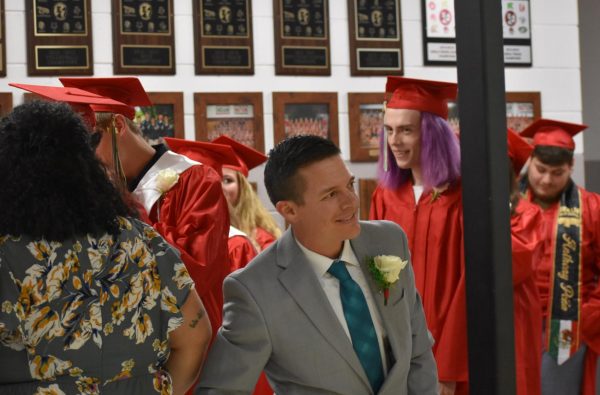 Assistant Principal Kurt Schommer and the 2024 class listen to the senior song from outside the gym before the graduation ceremony. The senior song was “Night Changes” by One Direction.