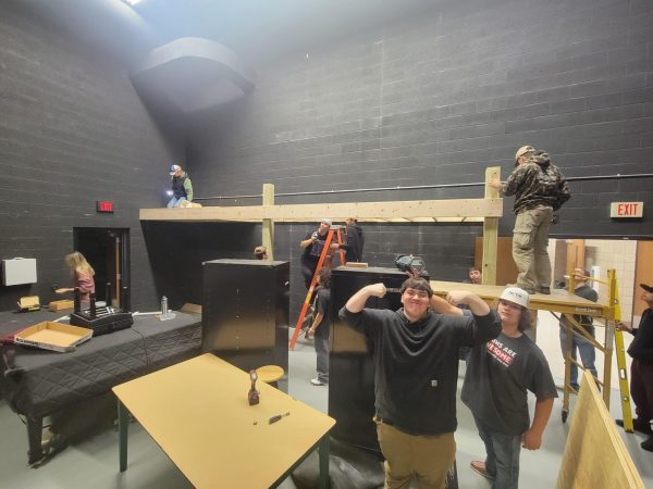 Seniors Jake Schroeder (left) and Jeremy Recore (right) pose as tech ed teacher Bryan Evans takes a photo of his class building new mezzanines in the auditorium. The second hour Building Trades class worked to build the mezzanines to help declutter the backstage area for any concert, performance, or program being held. 