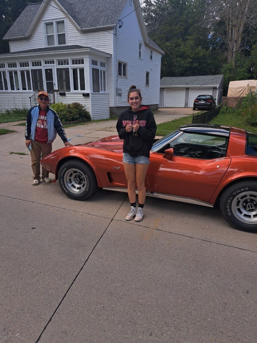 Junior Meradeth Reinsbach (in front of car) picks up her Corvette, nicknamed Gretta Vette, for the first time.