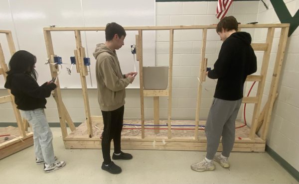 Left to right: sophomore Jazmyn Cerros, senior Fenix Cervantes, and senior Oliver Maxson work on fixing an electrical wire. “I learned how to wire certain switches and light fixtures and how to design our kitchens,” Cervantes said. 