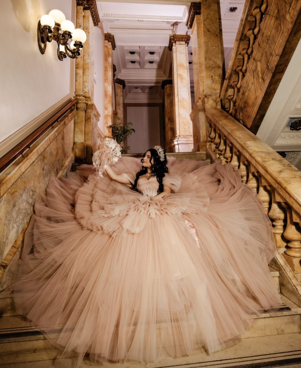 Sophomore Camila Villalobos poses on a stairwell for her pre-quinceañera photos, taken at Milwaukee Central Library in Milwaukee, WI. 
