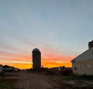 The Lemke family farm at dusk, with the sunset glowing behind silos, operates in Omro. “I live on the farm, and I’ve been involved with it my whole life,” junior Natalie Lemke said.