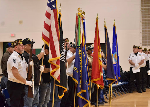 Honor guard members present their service flags, for the Veterans Day tribute.