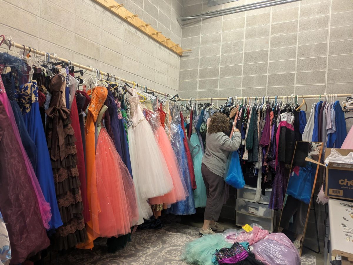 Guidance Counselor Ann Ragus organizes the dresses from smallest to largest in the Prom Dress Closet room located at Berlin High School. Alumna Isabelle Willett (‘20) started the Prom Dress Closet as a class project in 2020. “I really wanted to execute this project because I wanted people to experience a life milestone like prom, feeling like the most confident version of themselves,” Willett said.