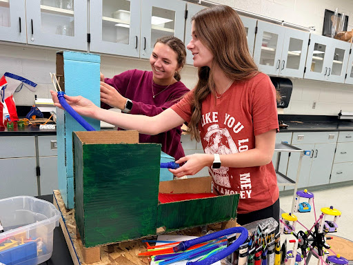 Seniors Ashley Dretske and Becca Bartol set up their Rube Goldberg machine. The group had decided to go with a carnival-themed mechanism. “Our last thing is we are sending a Ferris wheel spinning, and it's going to knock over a hammer, which hits some sort of lever. Kind of a challenge, though,” Dretske said.
