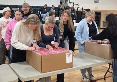 Seniors look through boxes of caps and gown sets to find their own in the gym on April 29. They were ordered in January, when they got their measurements taken. “It definitely felt unreal, like it’s not real to me that we’re graduating already. It’s just crazy to think about how high school’s already over; it went by really fast,” senior Lillian Johnson said.
