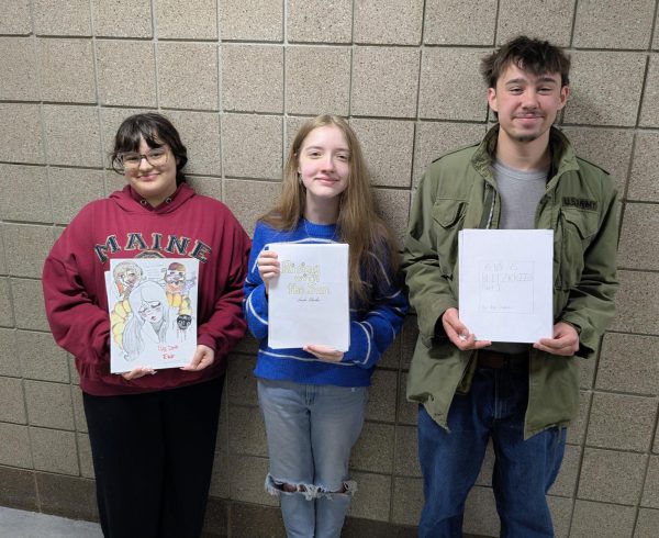 Participants of the eighth annual graphic short story competition stand with their winning stories. Third-place finalist Freshman Michaela Briski (left), first-place finalist Emelia Beulen (center), and second-place finalist Ray Daubner (right).
