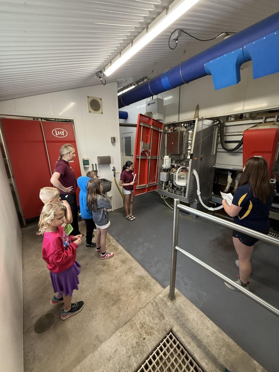 Berlin FFA members teach Clay lamberton first graders about the milking stations.